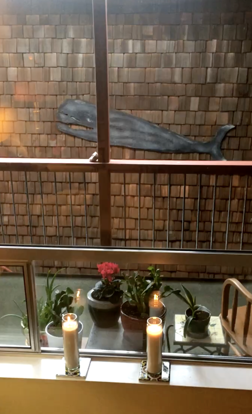 A wooden whale and candles by a window